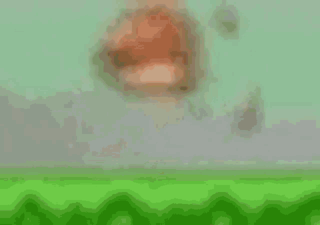 a blurred image of a person standing on top of a green field .