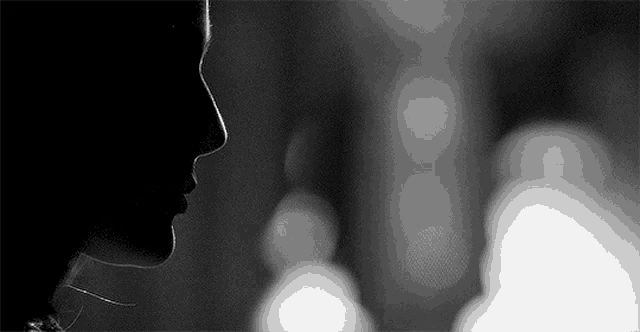 a black and white photo of a woman 's face with a blurry background .