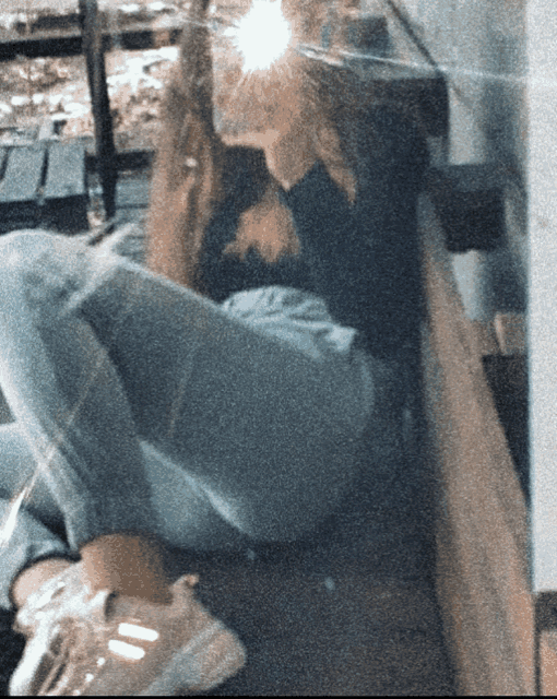 a blurry picture of a girl sitting on the ground