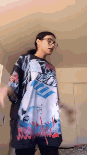 a woman wearing glasses and a shirt that says ' a ' on it