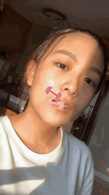 a young girl with a dumbbell on her face
