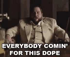 a man in a suit is sitting in a chair and yelling at someone .
