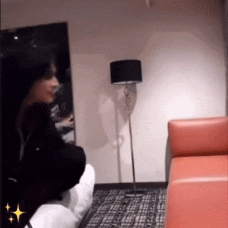 a person sitting on a couch in a living room with a lamp