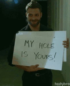 a man is holding up a sign that says my hole is yours