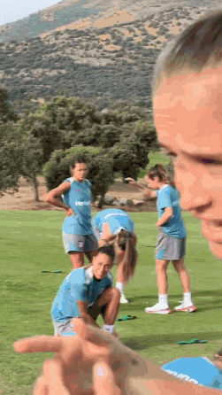 a group of female soccer players are on a field