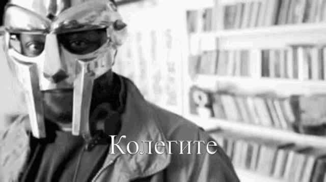 a man wearing a helmet and a jacket is standing in front of a shelf of books .