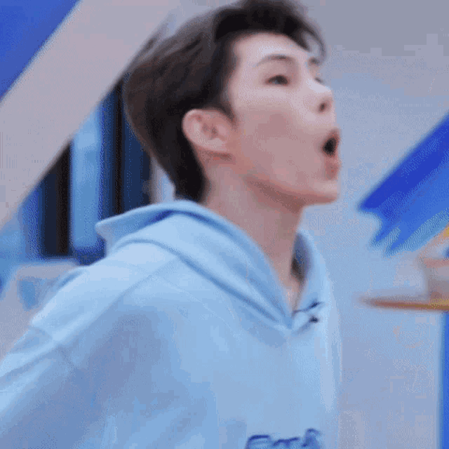 a close up of a man wearing a blue hoodie .
