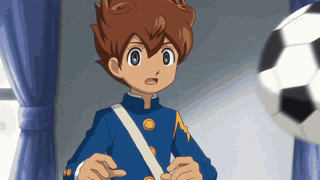 a boy in a blue uniform is standing in front of a window with a soccer ball in the background