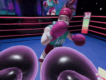 a woman wearing pink boxing gloves with the letter h on her shirt is in a boxing ring
