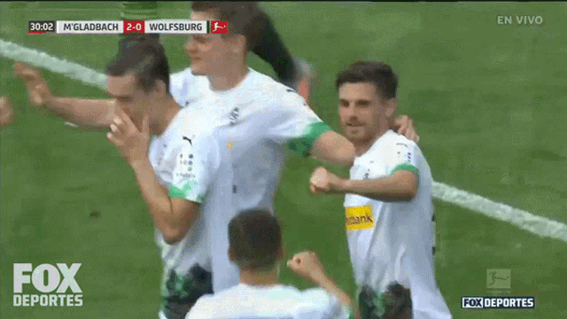 a group of soccer players are celebrating a goal on a fox deportes screen