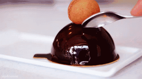 a person is using a spoon to scoop a chocolate dessert