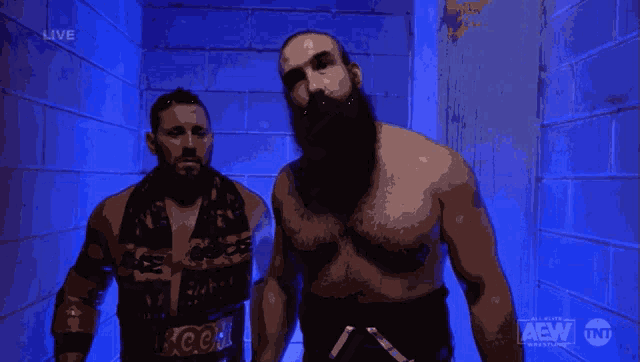 two men are standing next to each other in a dark room with the aew logo on the bottom