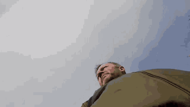 a man is standing in front of a cloudy sky looking up at the sky .