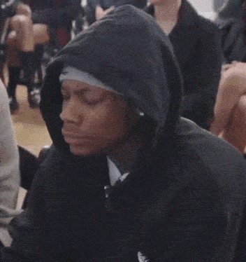 a man wearing a black hoodie with an adidas logo on the arm