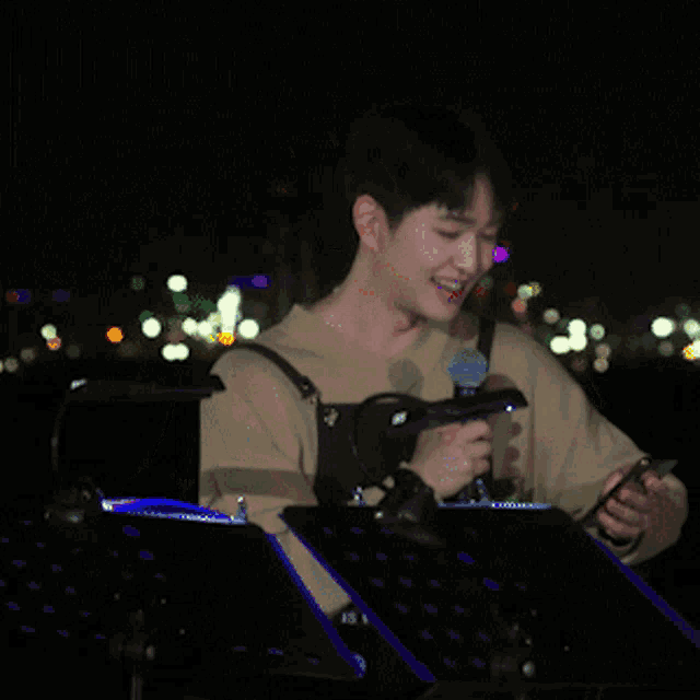 a man is playing drums in front of a microphone and smiling