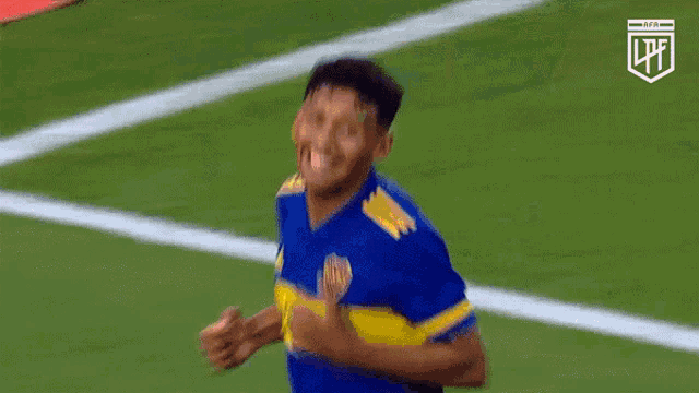a soccer player wearing a blue and yellow jersey with the word qatar on it