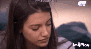 a close up of a woman 's face with her eyes closed and the words imgplay in the corner .