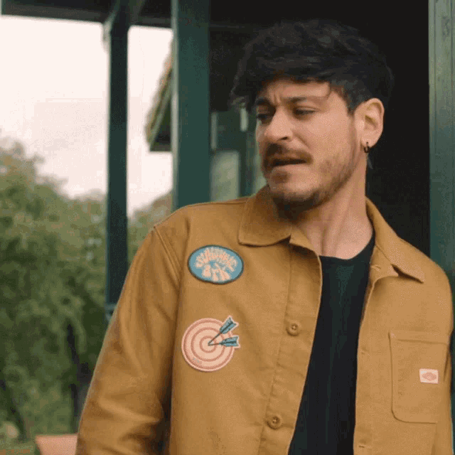 a man wearing a jacket with a patch that says " sharing " on it