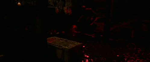 a person is laying in a coffin with red lights behind them