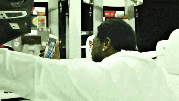 a man in a white shirt is holding a cell phone in his hand