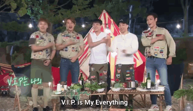 a group of men are standing around a table and one of them says v.i.p is my everything