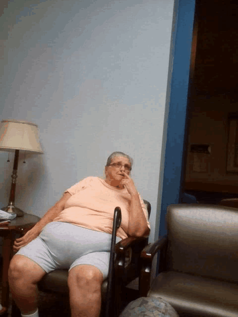 an elderly woman sits in a chair with a cane in her hand
