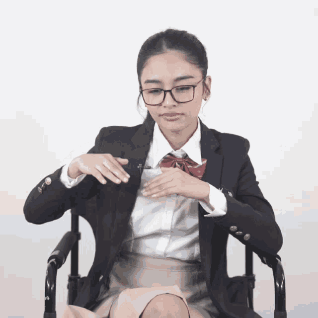 a woman in a school uniform is sitting in a chair