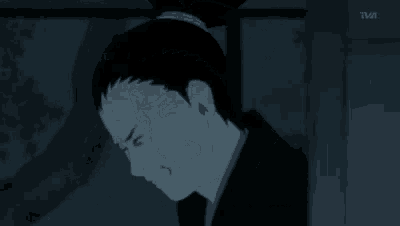 a close up of a person 's face with a ponytail in the dark .