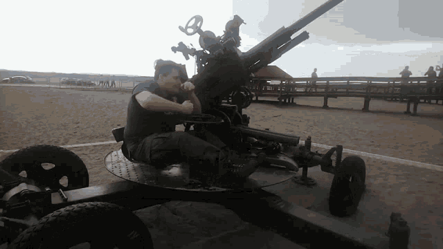 a man is sitting on a cannon with a steering wheel on it
