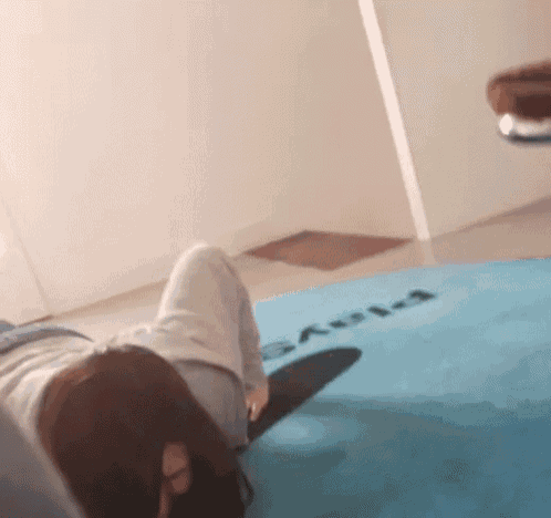 a person laying on a blue mat that says ' aula '