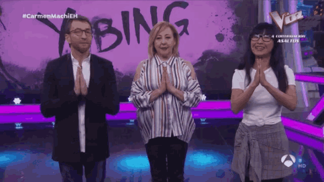 three people standing in front of a sign that says " bing "
