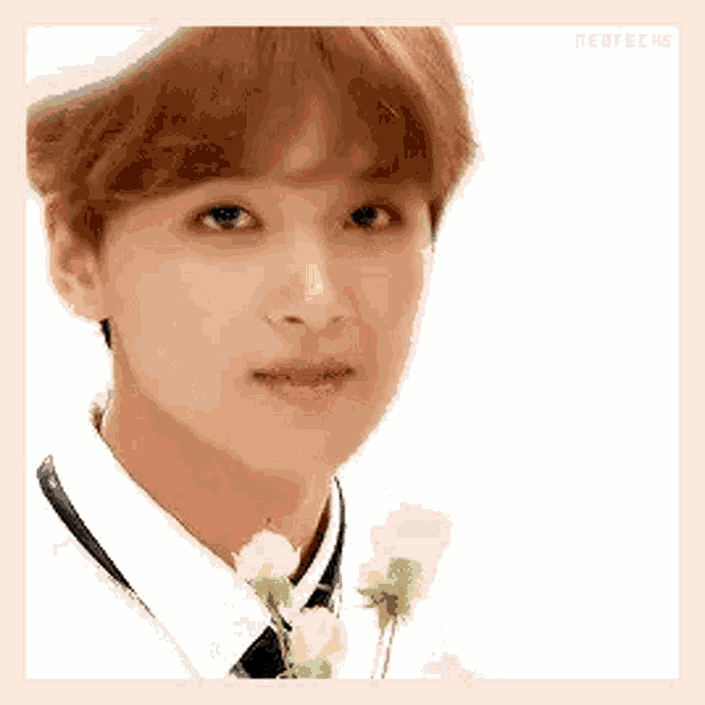 a close up of a young man holding a bouquet of flowers in his hand .