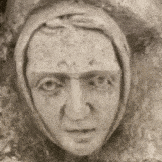 a black and white photo of a woman 's face with a scarf around her head