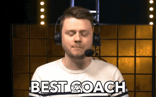 a man wearing headphones and a microphone with the words best coach on his shirt