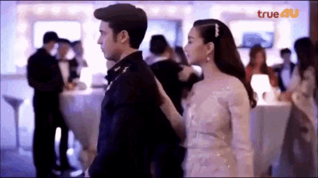 a man and a woman are dancing in a room with people .