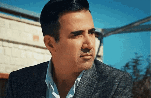 a man in a suit and white shirt is looking to the side
