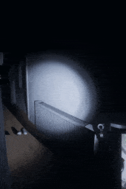 a dimly lit hallway with a radiator and a few shoes on the floor