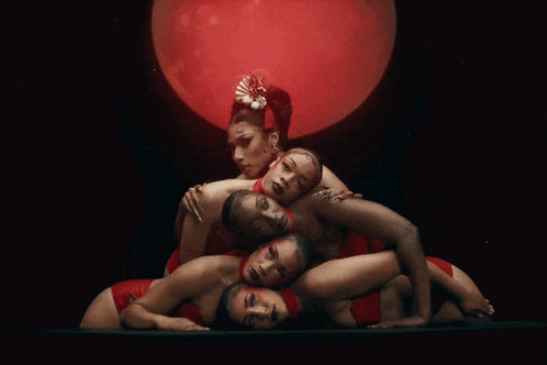 a woman with a flower in her hair is surrounded by four other women