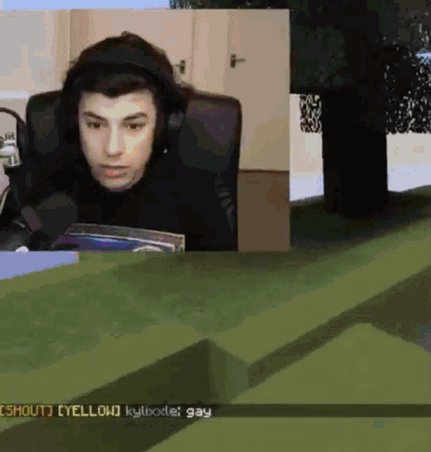 a man wearing headphones sits in front of a computer screen with a text box that says shout