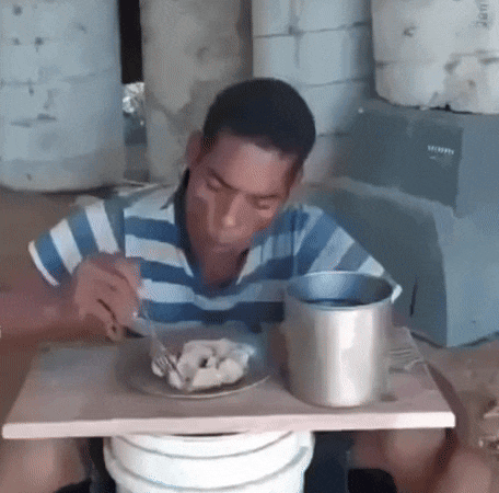 a man is sitting at a table with a plate of food