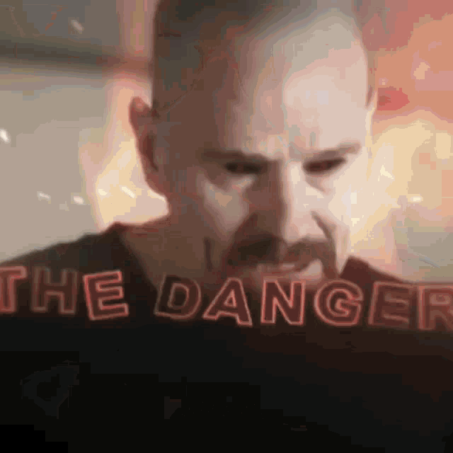 a man with a beard is looking at a screen with the word danger written on it