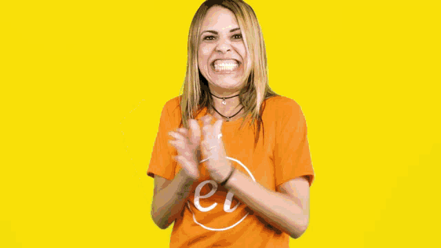 a woman wearing an orange t-shirt with the letter pi on it