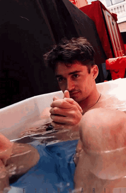 a man in a bathtub with the word ferrari on the bottom left