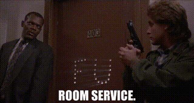 a man is holding a gun in front of a door that says room service
