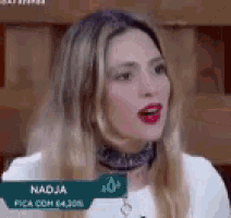 a woman wearing a choker and a white shirt is talking on a television show .