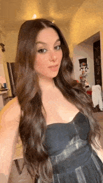 a woman with long hair is taking a selfie in a black dress .
