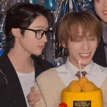a couple of people standing next to a cake that says xlov
