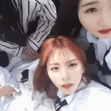 a group of young women are posing for a picture while laying on a bed .