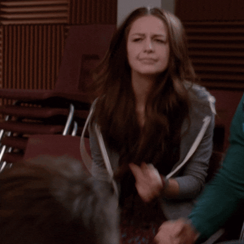 a woman with long brown hair is sitting in a chair