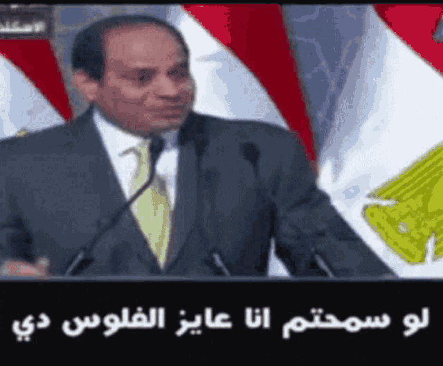 a man in a suit and tie is speaking into two microphones